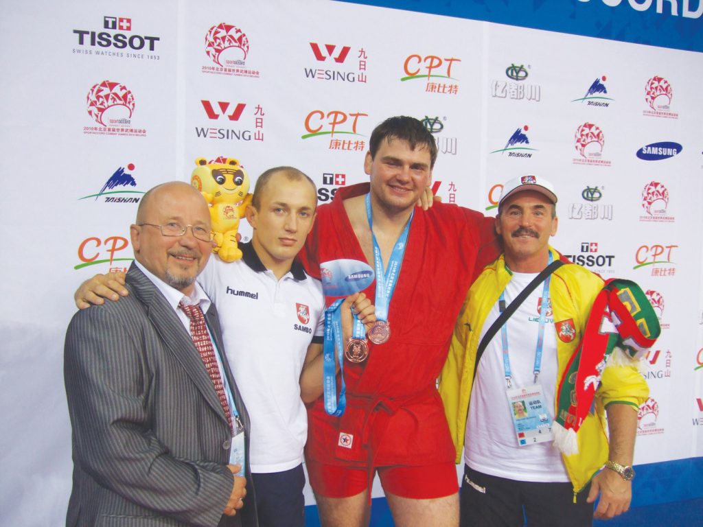 I pasaulio dvikovos sporto šakų žaidynių (2010) kovinės savigynos varžybų bronzos medalininkai S. Grečicha ir T. Rimkevičius (antras ir trečias iš kairės) su savo treneriais E. Rudu (pirmas iš kairės) ir S. Kulikausku